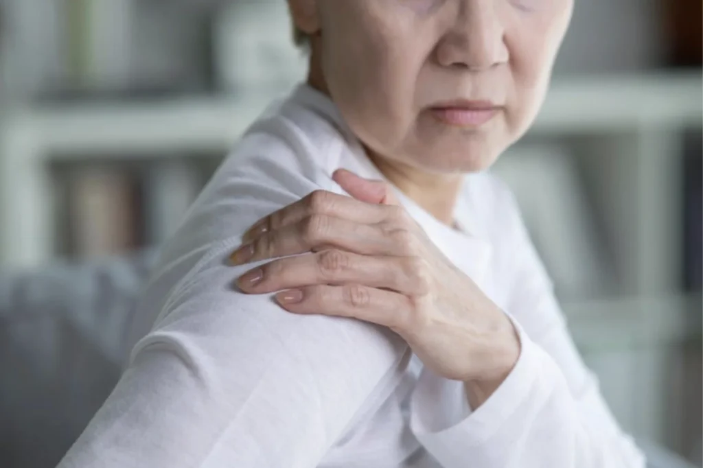 Older woman holding shoulder