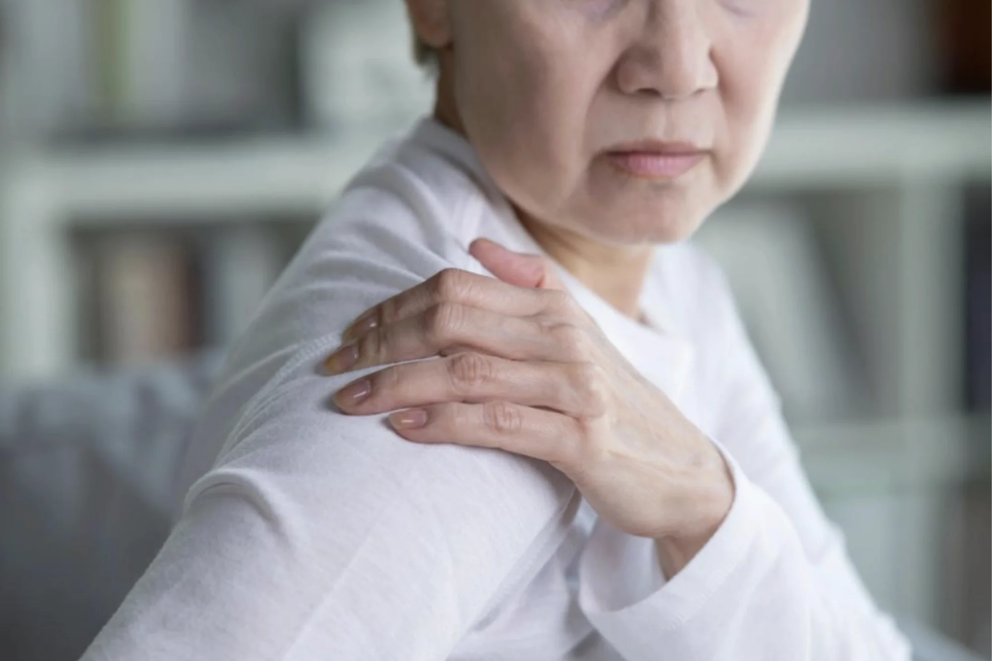 Older woman holding shoulder