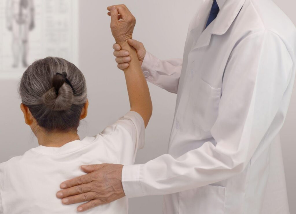 Woman raising shoulder to get checked by doctor